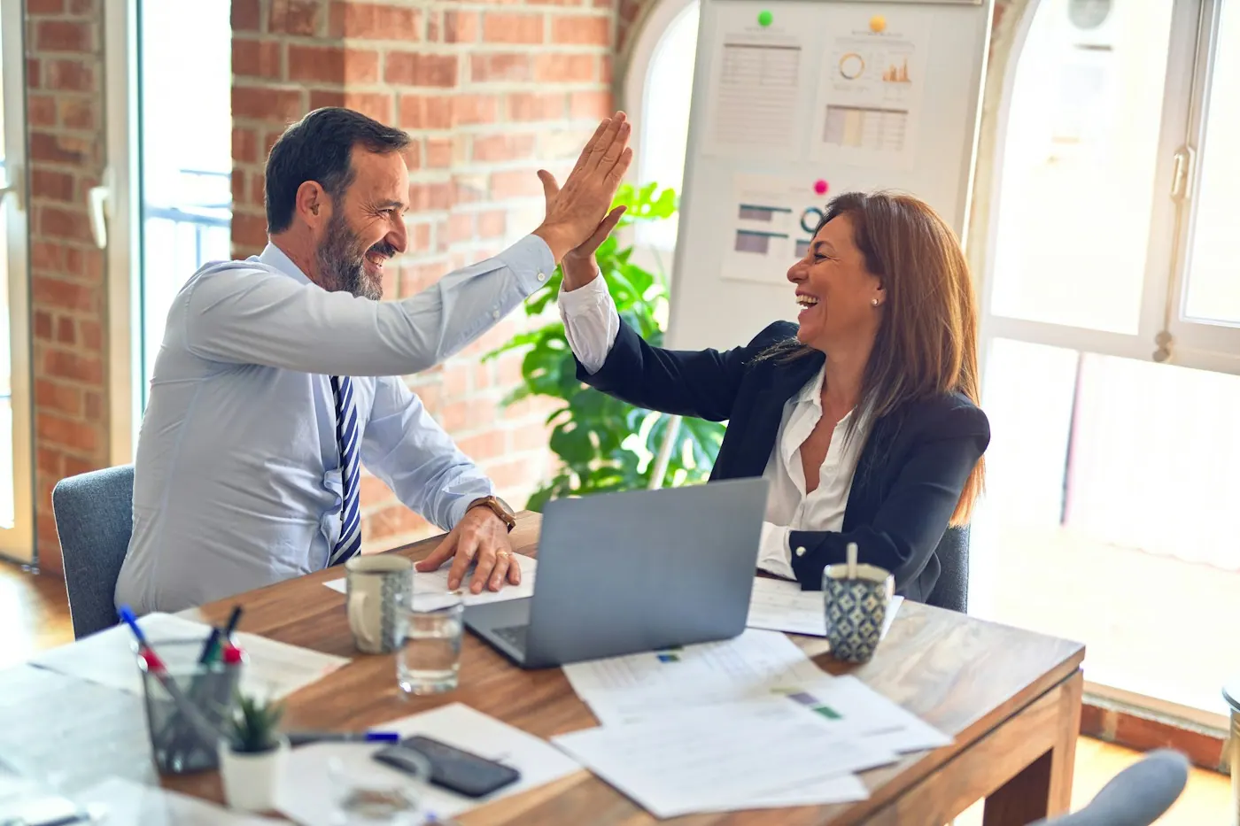 Two DyBilling account managers reviewing a practice report together at an office desk