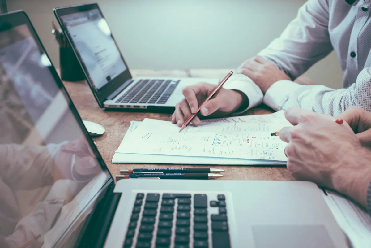 Medical billing services specialist reviewing paper claims and remittances at a billing desk