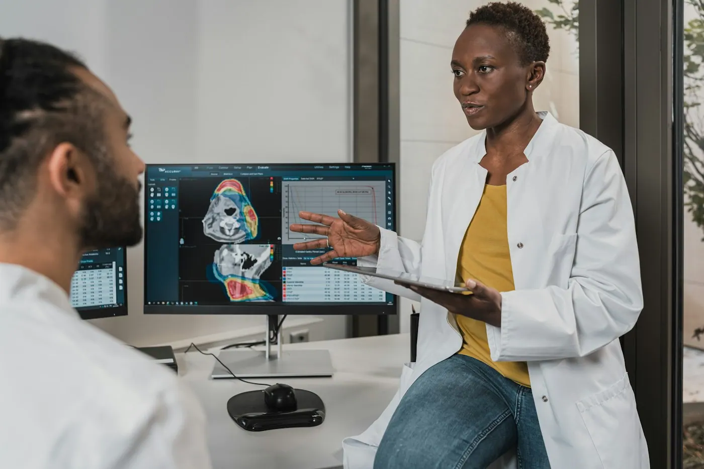 Physician reviewing patient records on a tablet in a clinic office