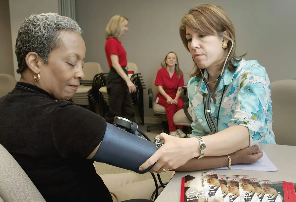 Clinic staff member explaining a patient billing statement and payment plan to a patient at the desk