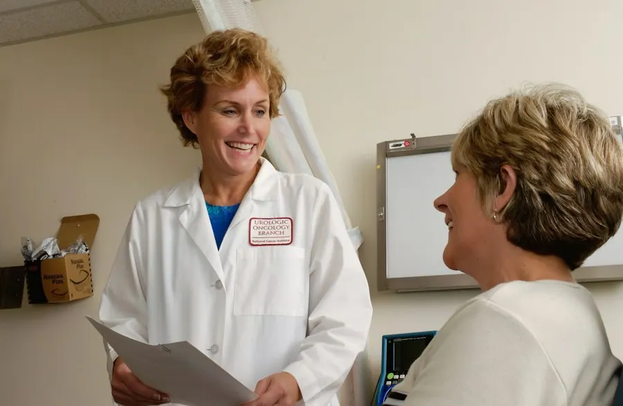 Family physician in a white coat going over paperwork with a patient in an exam room, family practice billing services
